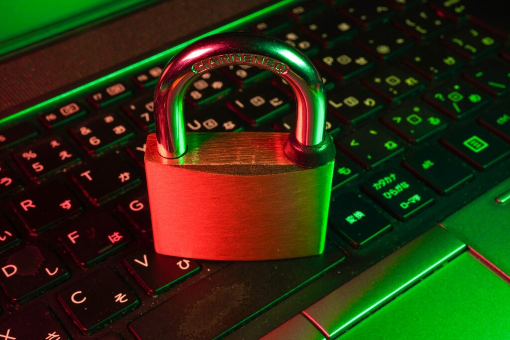 Cybersicherheit im Unternehmen: rotes Vorhängeschloss auf einer schwarzen Computertastatur