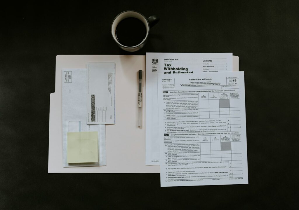 Steuerformulare, Stift und Kaffeetasse auf einem Schreibtisch bei der Umstellung auf die E-Rechnung