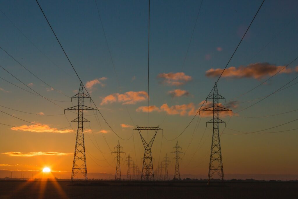Hochspannungsmasten vor blauem Himmel – Energieverträge Unternehmen klug planen