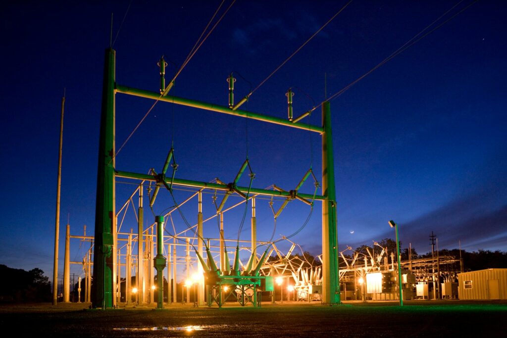 Strommast bei Nacht als Sinnbild für Versorgungssicherheit in Energieverträgen