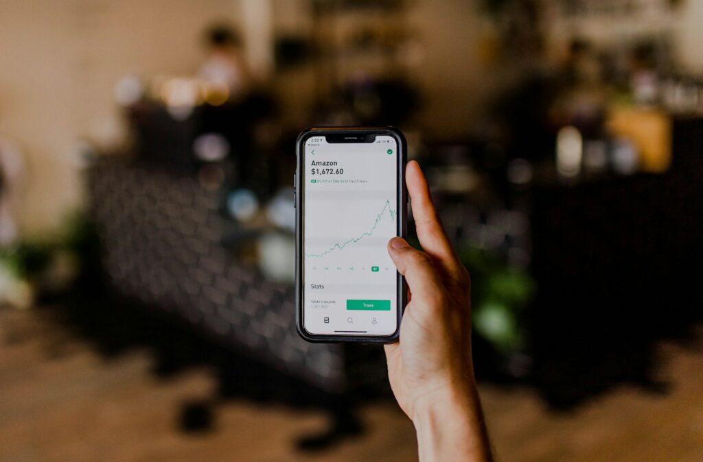 Hand hält Smartphone mit Börsenkursen