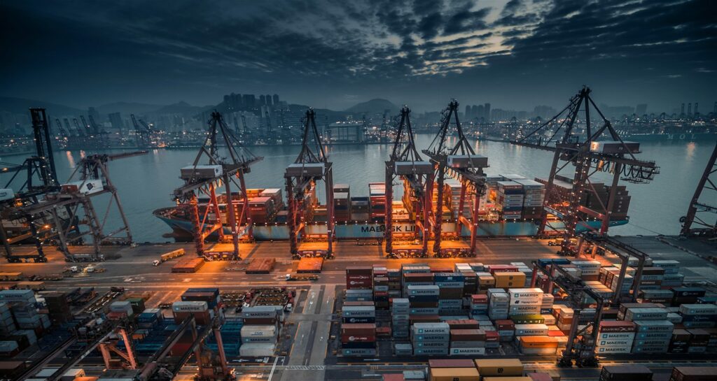 Containerschiff wird in der Abenddämmerung im Hafen beladen