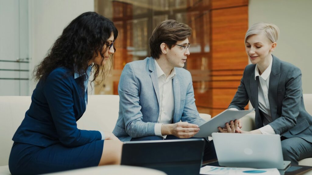 Unternehmer besprechen Unterlagen zu Firmenkredit Alternativen am Besprechungstisch