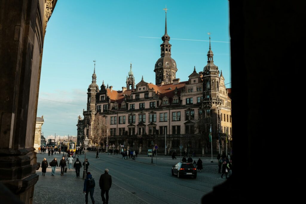 Menschen auf einem Platz vor historischen Gebäuden in Dresden als Standort für Investitionen in Ostdeutschland