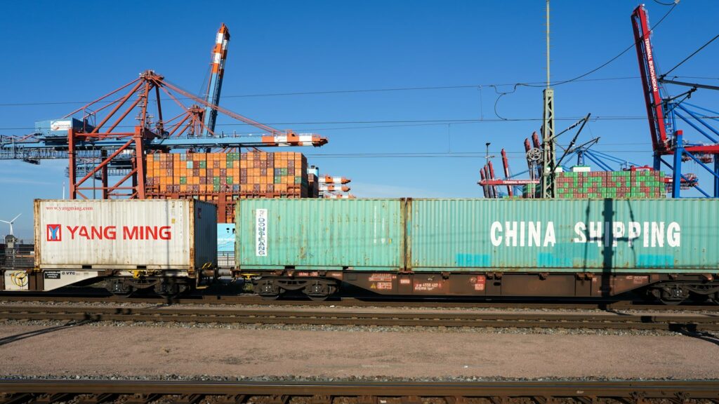 Nearshoring Lieferketten: Container werden in einem Hafen auf einen Güterzug verladen