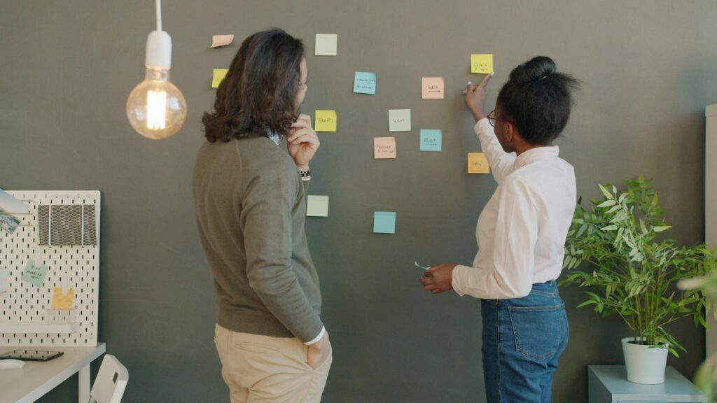 Zwei Gründer planen mit Haftnotizen an der Wand, bevor sie ein Unternehmen gründen
